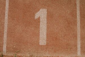 Close-up image of number one lane on a running track, symbolizing first place.